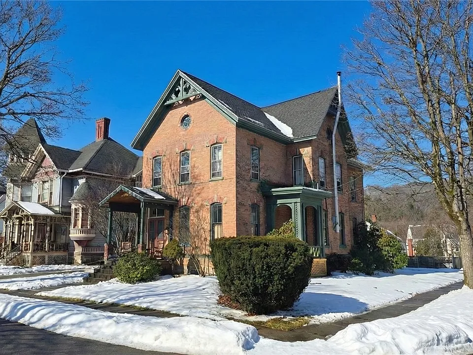 Beautiful woodwork & grand staircase! C. 1900 brick Victorian in New York. $249,900.